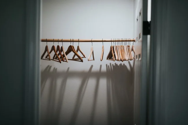 A small walk-in closet with double-hanging rods