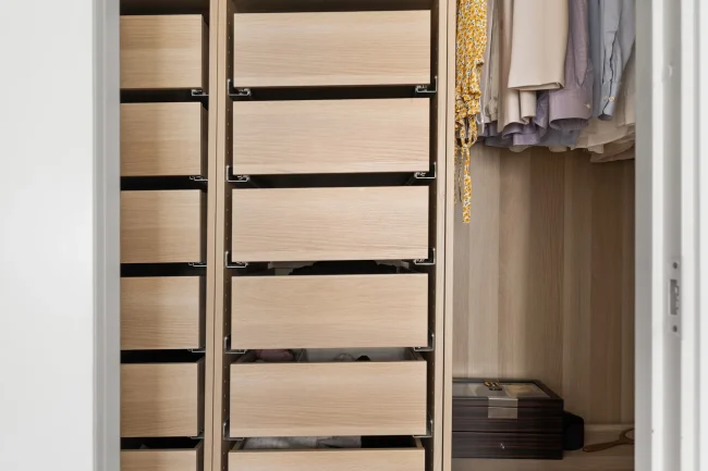 Small walk-in closet with vertical storage and pull-out shelves