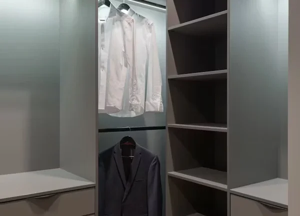 Modern walk-in closet system with white built-in cabinets and ample lighting