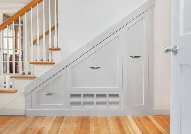 custom closet system under stairs with built-in shelves and drawers for maximum storage