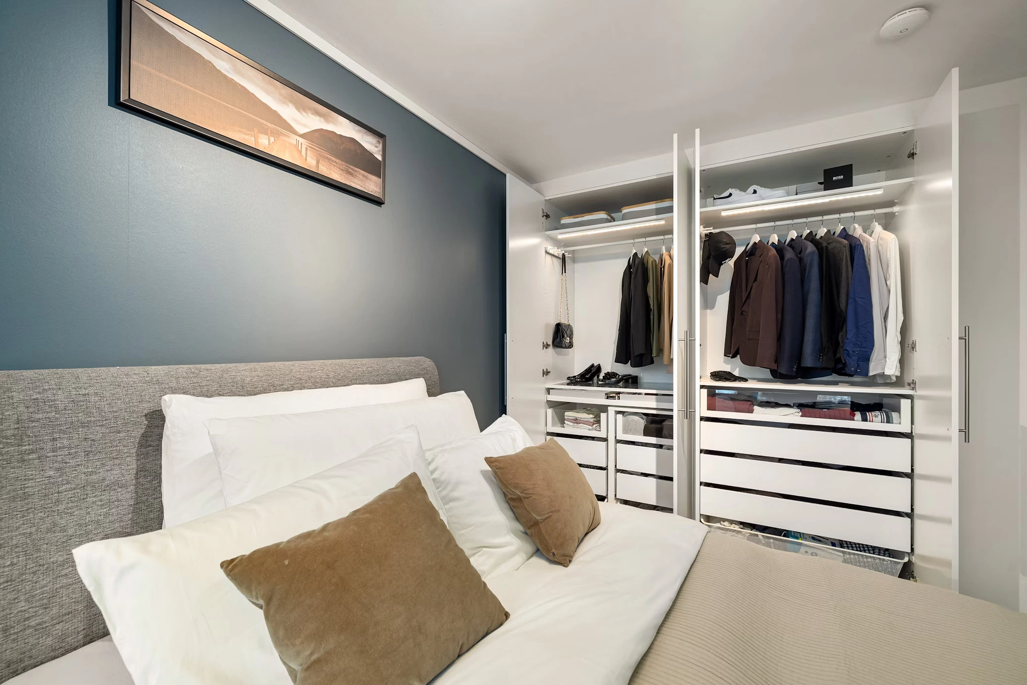Custom closet cabinet system matching neutral modern bedroom interior