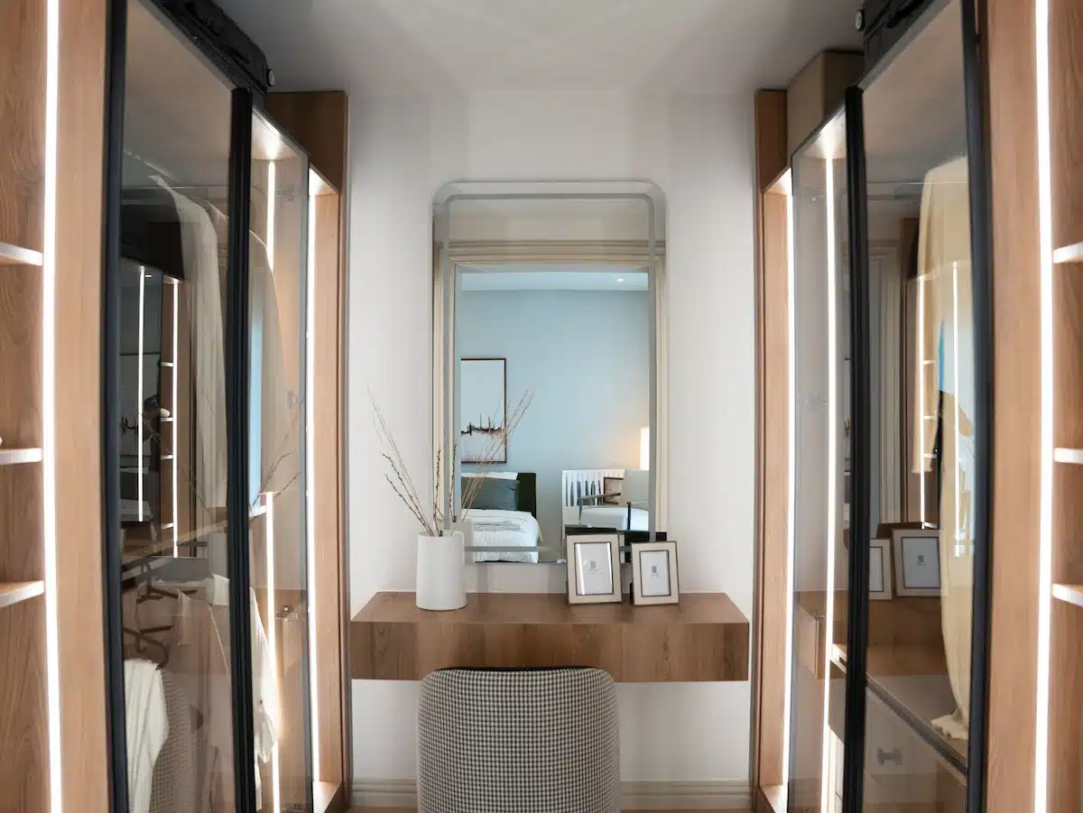 walk-in master closets designed as luxury dressing rooms with warm wood cabinetry and vanity station