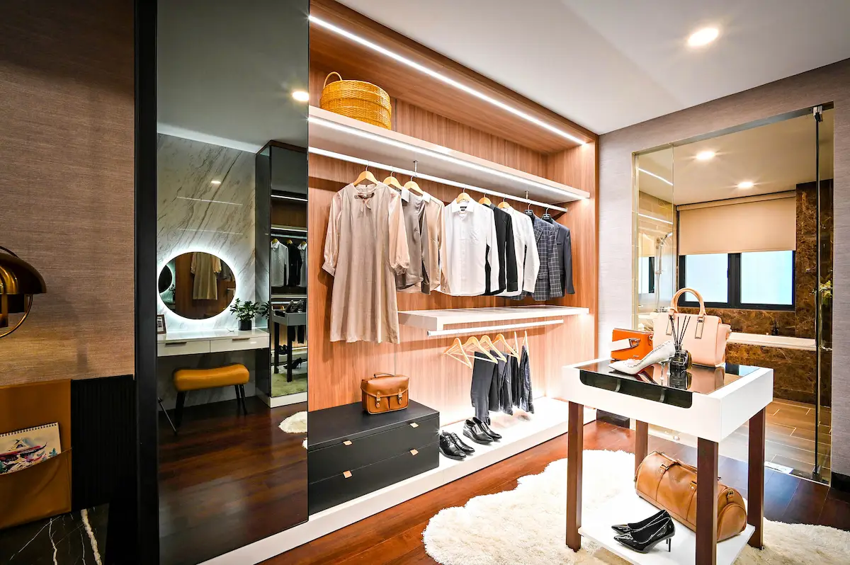walk-in master closets with white cabinetry center island and integrated lighting by Closet & Beyond